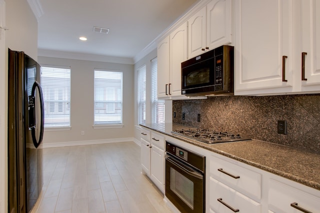 kitchen with crown molding, tasteful backsplash, black appliances, white cabinets, and dark stone counters