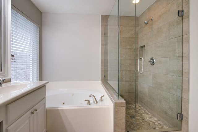 bathroom with vanity and shower with separate bathtub