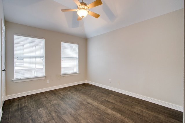 spare room featuring dark wood-type flooring, vaulted ceiling, and ceiling fan