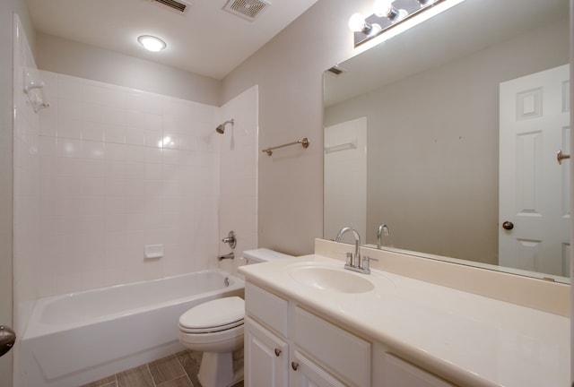 full bathroom featuring tiled shower / bath, vanity, and toilet