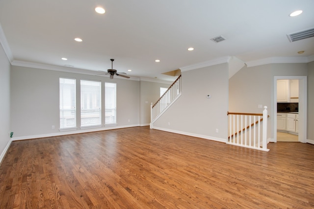 empty room with crown molding, ceiling fan, and light wood-type flooring