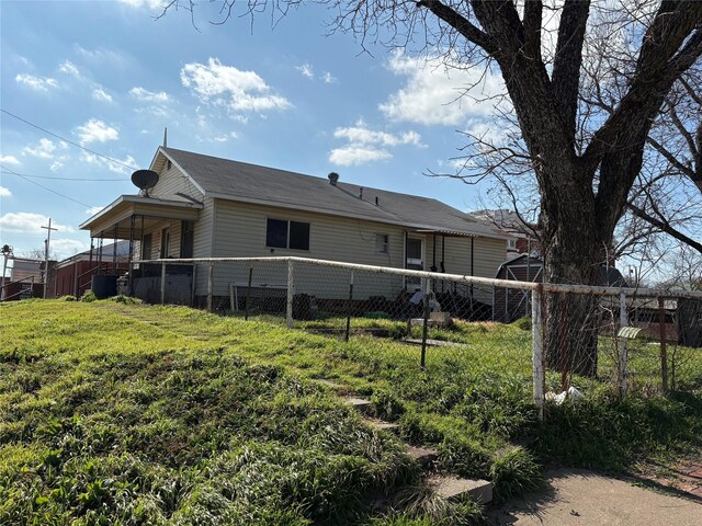 view of front of property featuring cooling unit and a front lawn