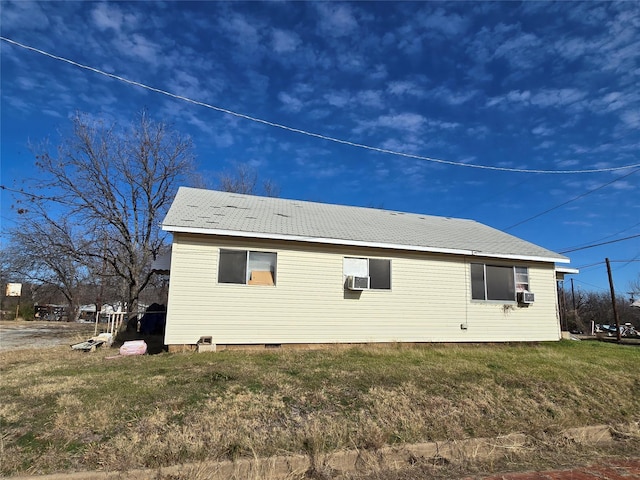 view of side of home featuring cooling unit and a lawn