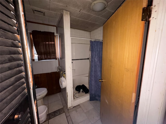 bathroom with toilet, tile patterned floors, and a shower with curtain