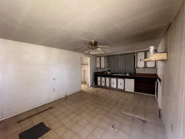 kitchen featuring sink, a textured ceiling, and ceiling fan