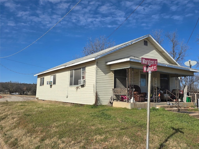 view of front of home with cooling unit and a front lawn