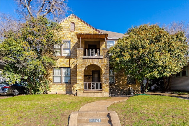 view of front of home featuring a front lawn and a balcony