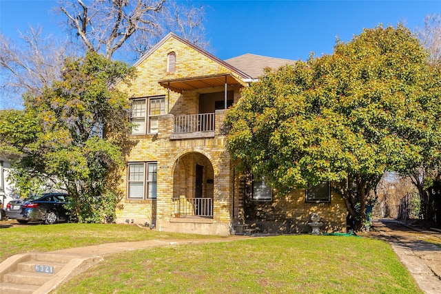 view of front facade with a balcony and a front yard