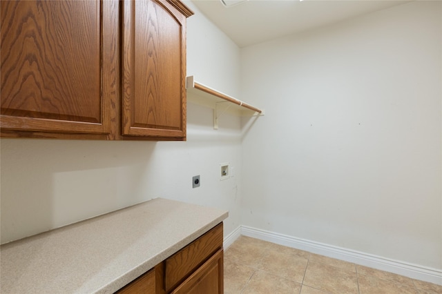 laundry room with electric dryer hookup, hookup for a washing machine, cabinets, and light tile patterned flooring