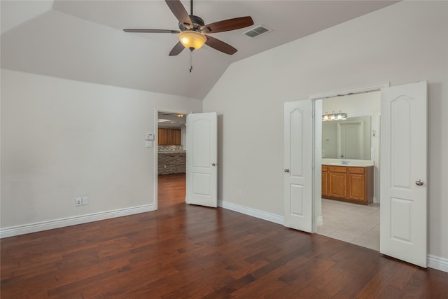 unfurnished bedroom with lofted ceiling, connected bathroom, ceiling fan, and light wood-type flooring