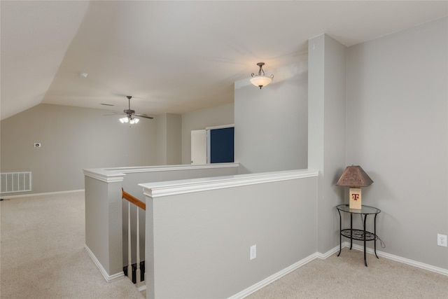 corridor featuring lofted ceiling and light colored carpet