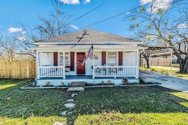 bungalow featuring a front lawn, a carport, and covered porch