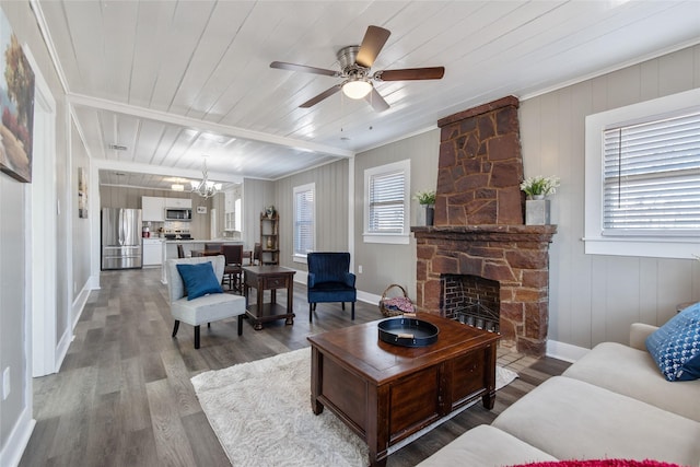 living room featuring hardwood / wood-style flooring, wood ceiling, a stone fireplace, and ceiling fan with notable chandelier