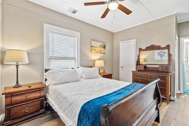 bedroom with crown molding, light hardwood / wood-style flooring, and ceiling fan