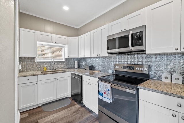 kitchen with light stone counters, sink, white cabinets, and appliances with stainless steel finishes