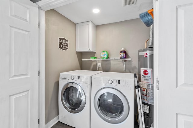 laundry room with water heater, separate washer and dryer, and cabinets