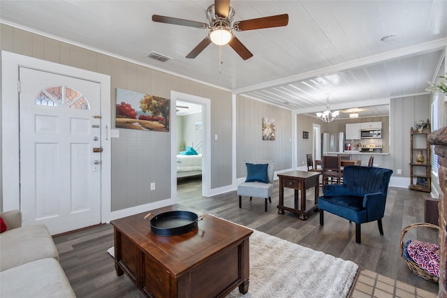 living room with wood-type flooring, ceiling fan with notable chandelier, and crown molding