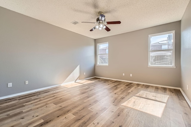 unfurnished room featuring ceiling fan, hardwood / wood-style floors, and a textured ceiling