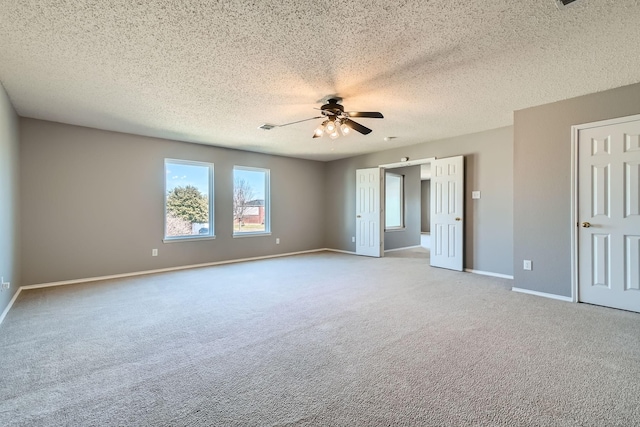 unfurnished room with ceiling fan, light carpet, and a textured ceiling