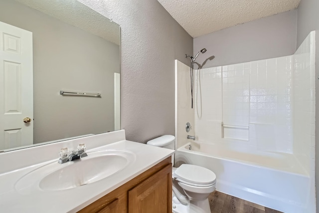 full bathroom with toilet, bathing tub / shower combination, a textured ceiling, vanity, and hardwood / wood-style floors