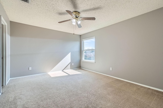 carpeted empty room with ceiling fan and a textured ceiling