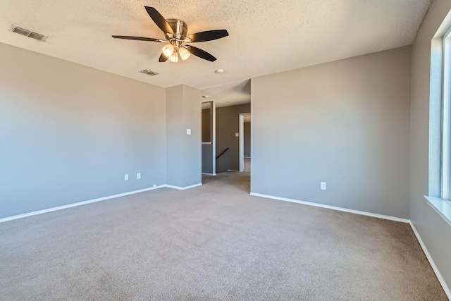 carpeted empty room featuring ceiling fan and a textured ceiling