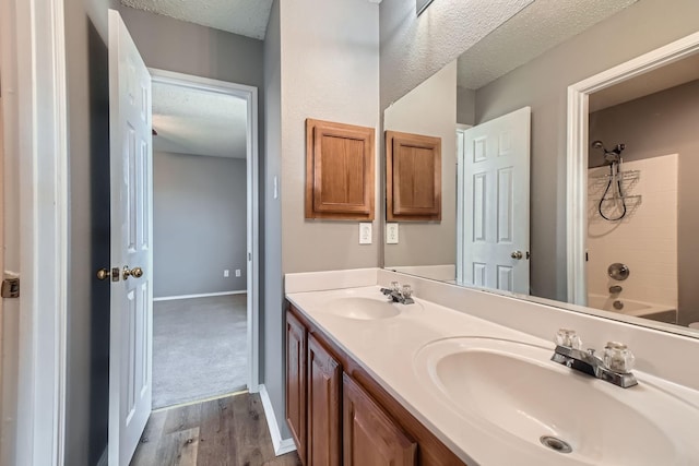 bathroom with vanity, tub / shower combination, wood-type flooring, and a textured ceiling