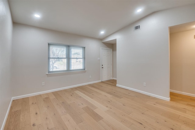 unfurnished room with vaulted ceiling and light hardwood / wood-style flooring