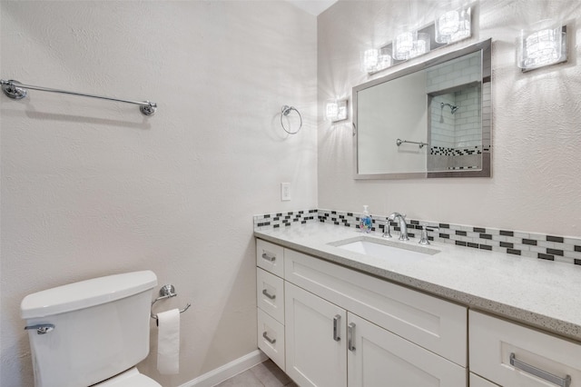 bathroom with vanity, toilet, and backsplash