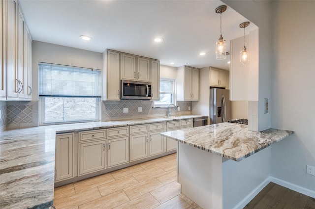 kitchen with appliances with stainless steel finishes, pendant lighting, sink, backsplash, and light stone countertops