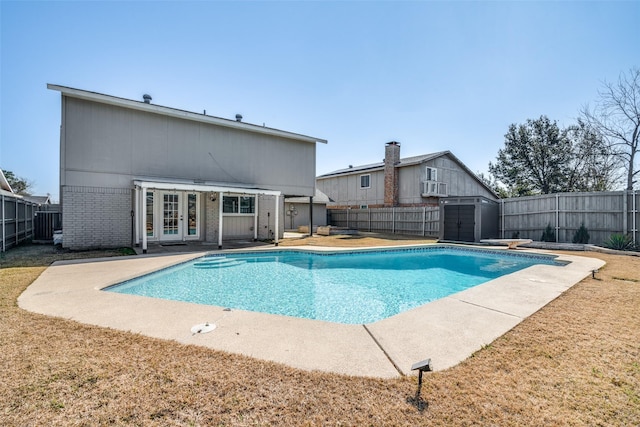 view of swimming pool with a storage unit, a yard, a diving board, and a patio