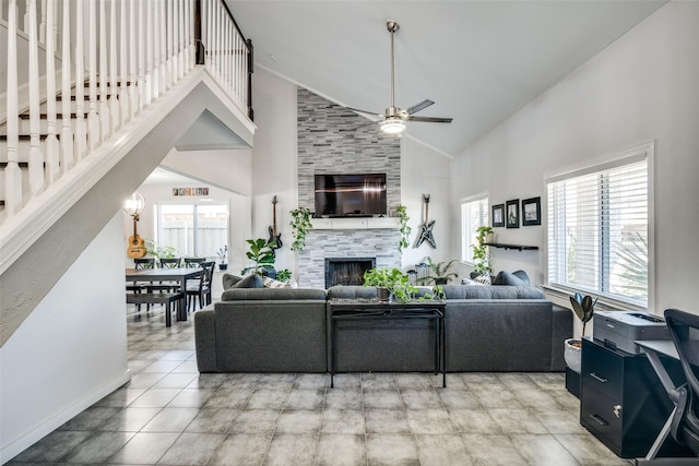 living room with ceiling fan, tile patterned flooring, high vaulted ceiling, and a tile fireplace