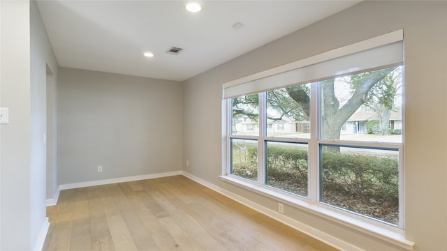 unfurnished room with a wealth of natural light and light hardwood / wood-style flooring