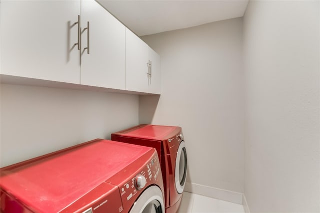 laundry room with washer and clothes dryer and cabinets