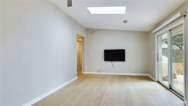 unfurnished living room featuring light hardwood / wood-style floors and a skylight