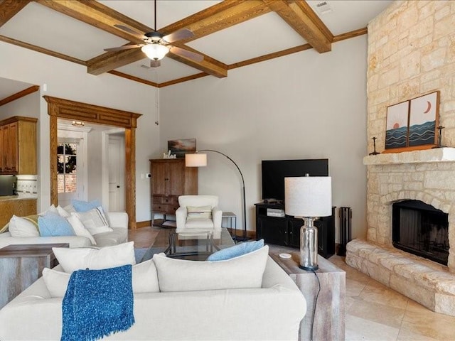 living room featuring coffered ceiling, ceiling fan, a stone fireplace, and beamed ceiling