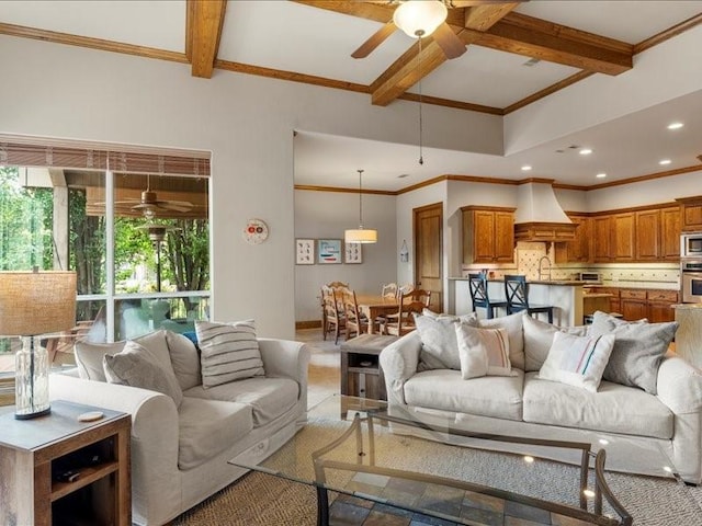 living room with ceiling fan, sink, crown molding, and beam ceiling