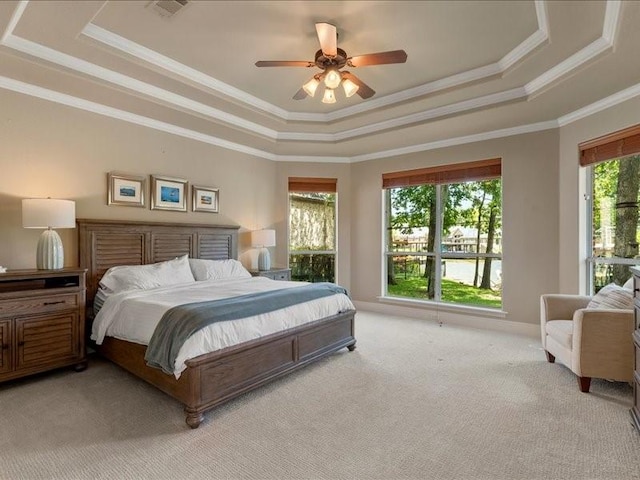 carpeted bedroom featuring crown molding, a tray ceiling, and ceiling fan