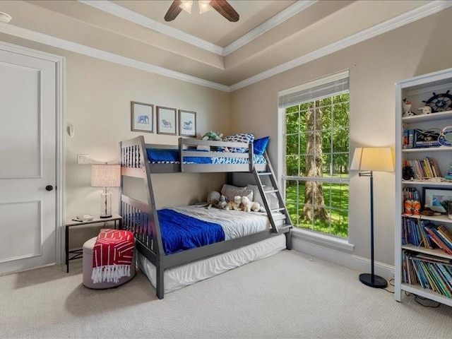 carpeted bedroom featuring crown molding, a raised ceiling, and ceiling fan