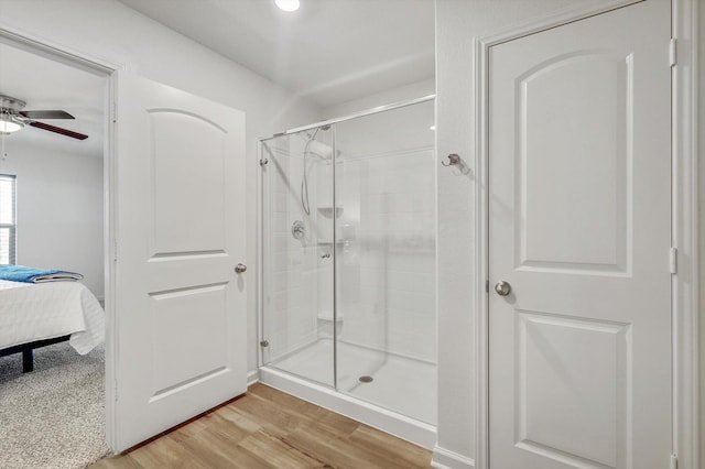 bathroom with hardwood / wood-style flooring, ceiling fan, and walk in shower