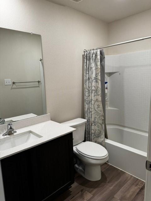 full bathroom with shower / tub combo, vanity, hardwood / wood-style flooring, and toilet