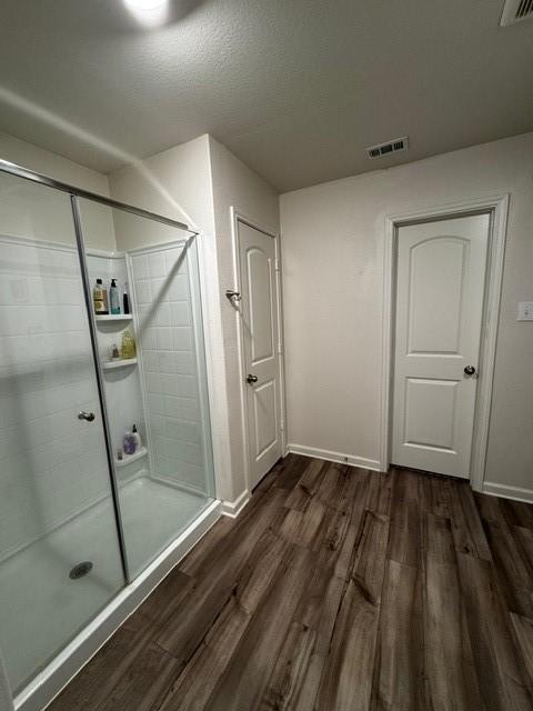 bathroom featuring hardwood / wood-style flooring and an enclosed shower