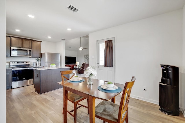 dining space featuring ceiling fan and light wood-type flooring