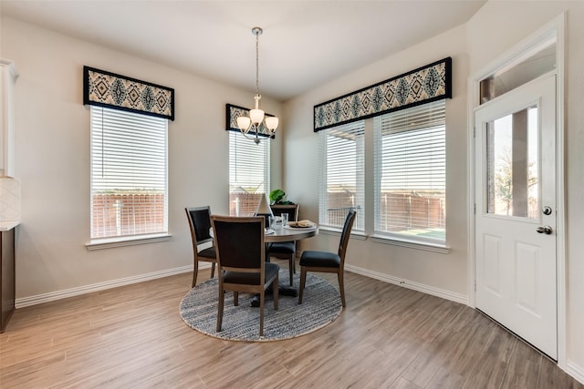 dining area with a notable chandelier and light hardwood / wood-style floors