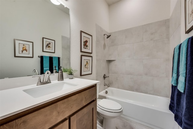 full bathroom featuring tiled shower / bath, vanity, and toilet