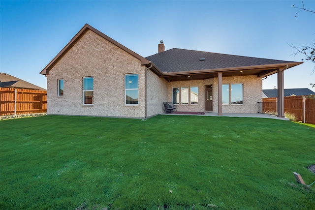 rear view of property featuring a yard and a patio