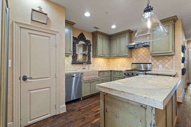 kitchen with dark wood-type flooring, appliances with stainless steel finishes, hanging light fixtures, light stone counters, and tasteful backsplash