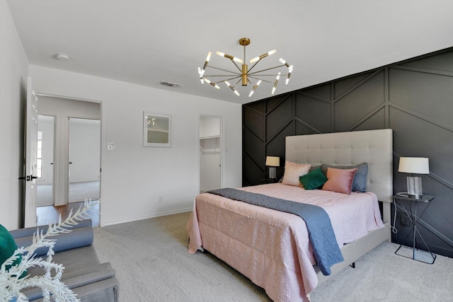 bedroom with an inviting chandelier, a spacious closet, and carpet flooring