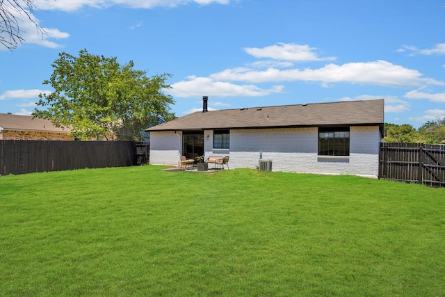 rear view of property with a yard, central AC, and a patio area