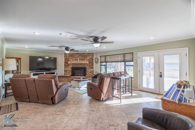 tiled living room with crown molding, ceiling fan, a fireplace, and french doors